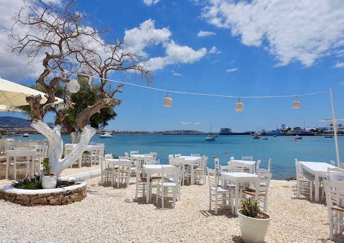 Un restaurant de bord de mer et le port d'Antiparos