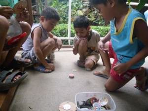 Kids playing the ancient game of Pog in El Nido El Nido, Philippines - Soleil et découverte des îles - El Nido, Philippines - Soleil et découverte des îles